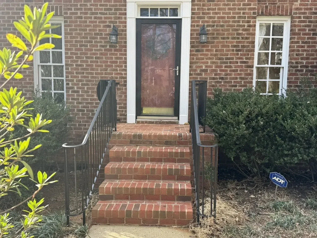 cleaned red brick home with steps and red door