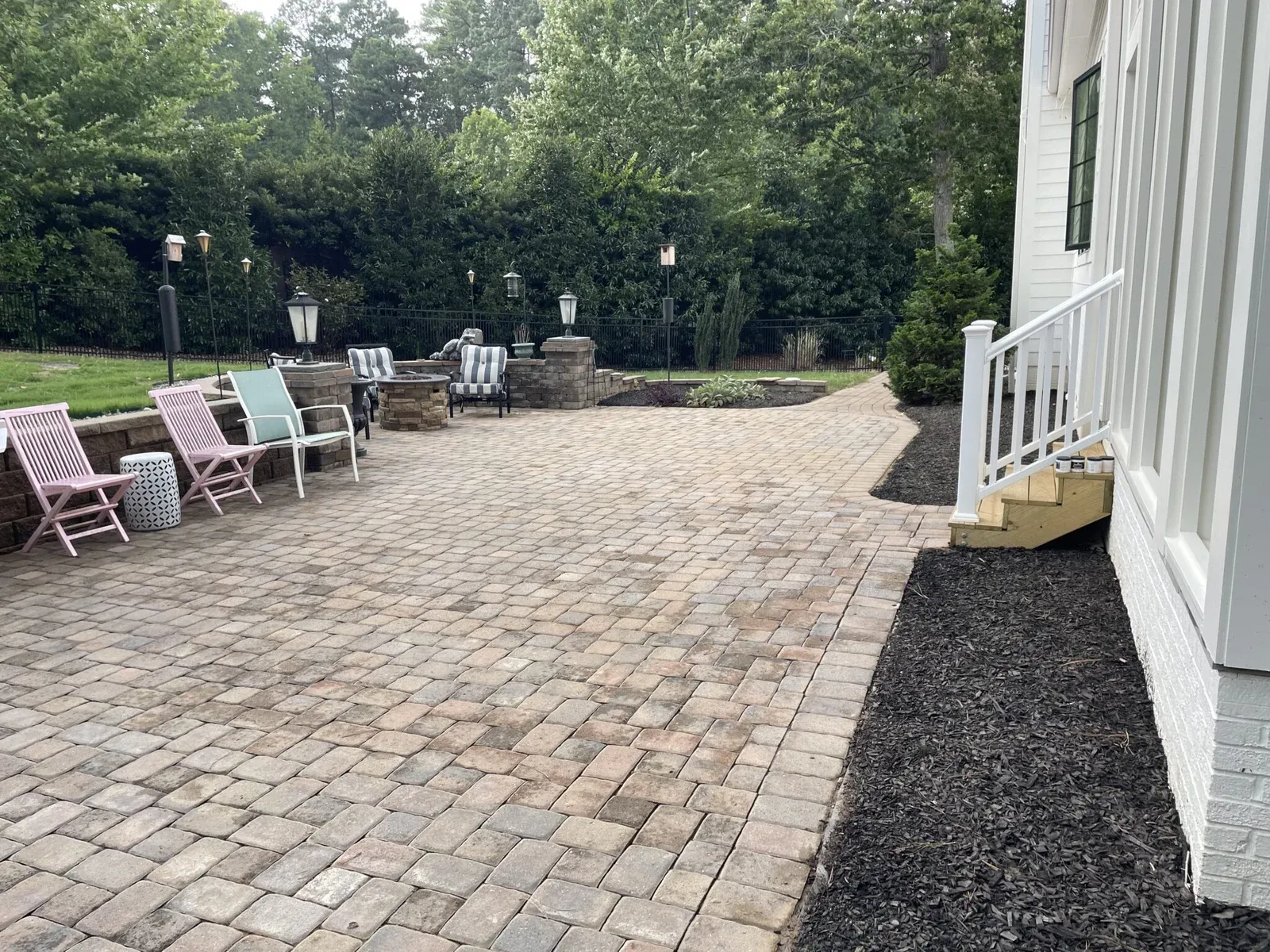 wide view picture of dirty, stained patio with house and chairs in view, wake forest nc