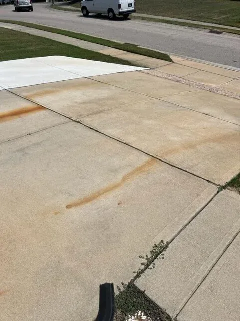 dark rust stains on a driveway before cleaning in Wake Forest NC