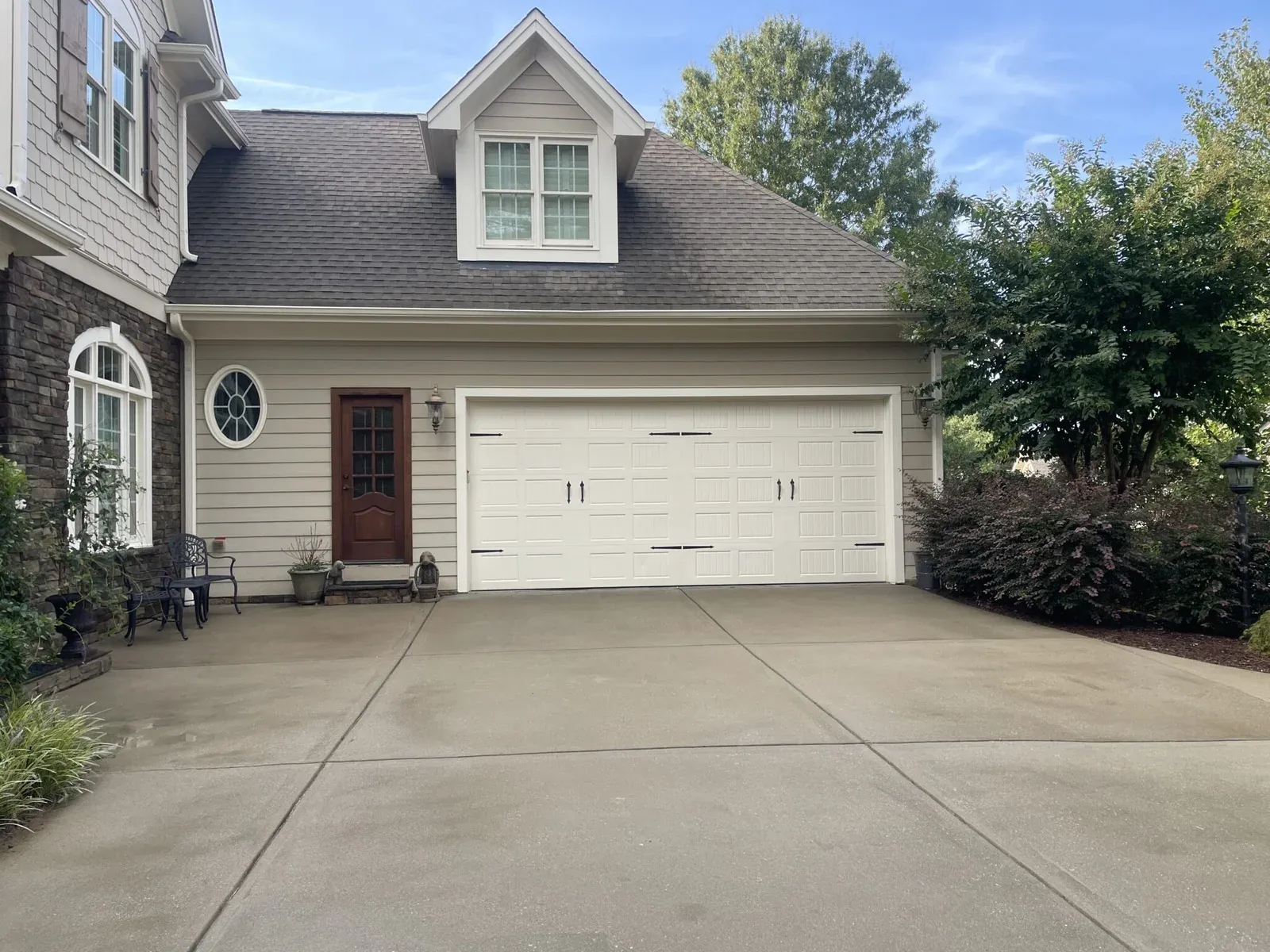 Facing the house showcasing a wet, clean driveway in Wake Forest NC after powerwashing